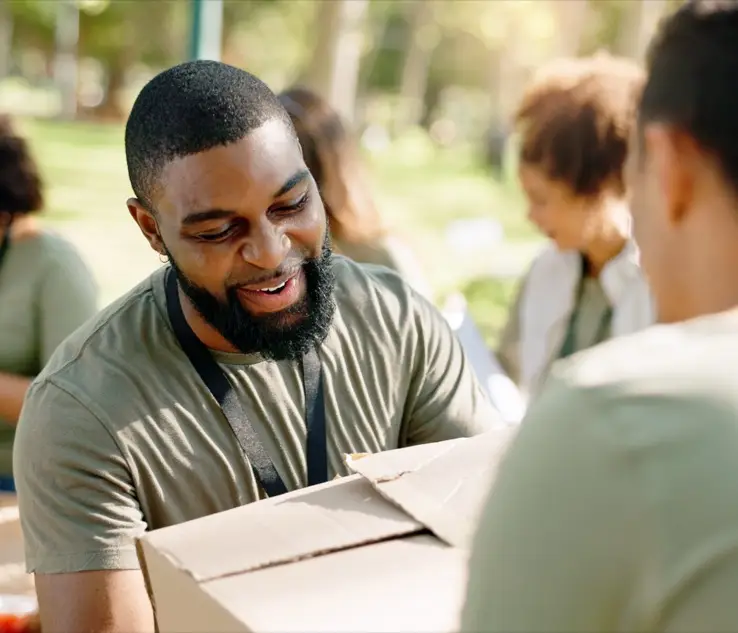 Un voluntario cargando una caja de donaciones