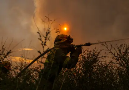 Bombero con una manguera echando agua