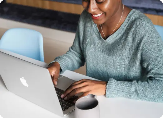Person using a laptop at a desk, representing Worldcoo's online donation platform and digital services