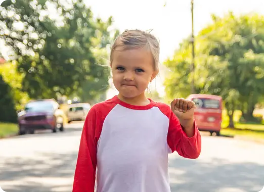 Young child standing outdoors looking at the camera, symbolizing communities supported by donations
