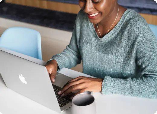 Person using a laptop at a desk, representing Worldcoo's online donation platform and digital services