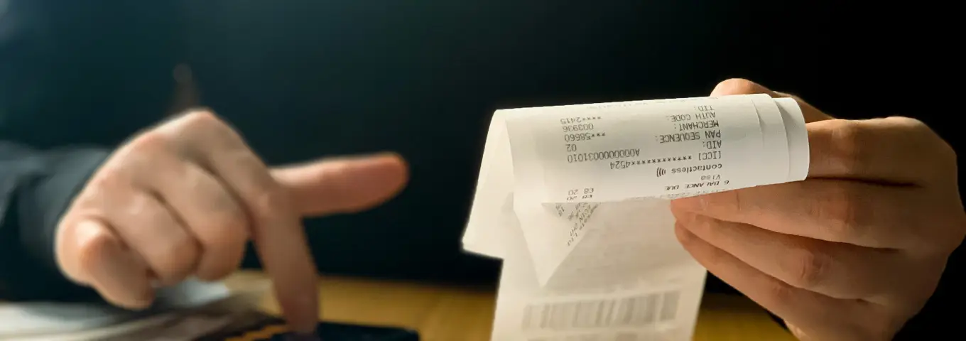 Mans amb un tiquet i una calculadora