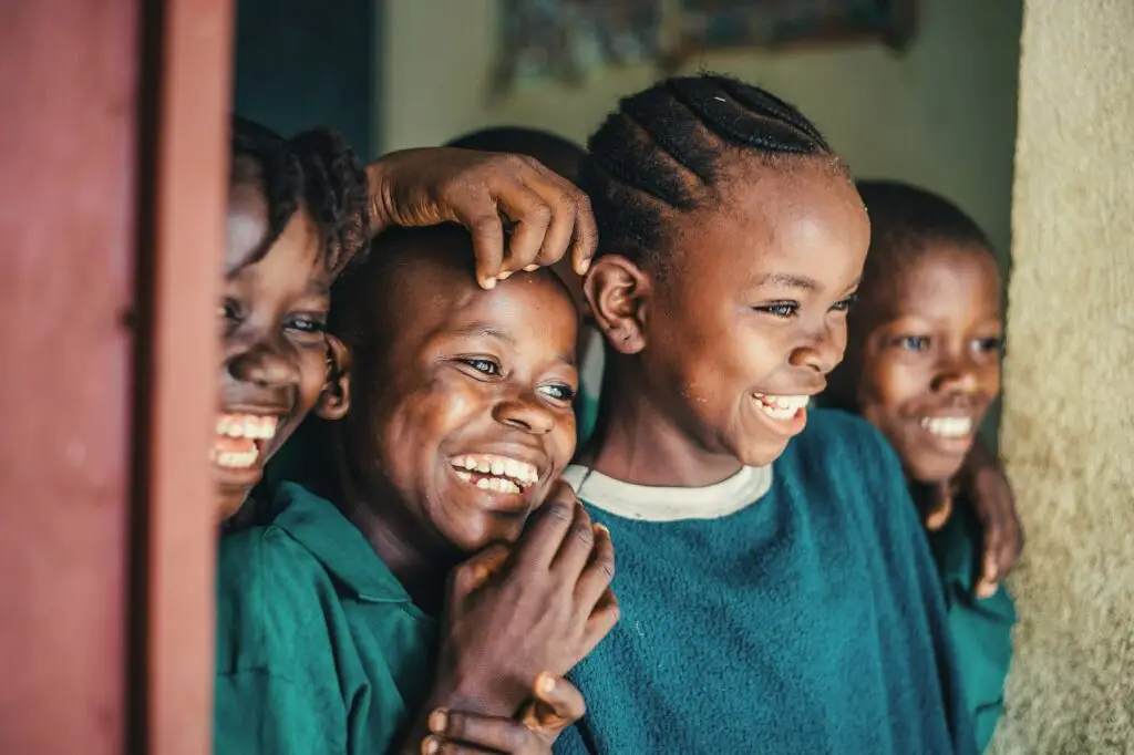 Niños sonriendo delante de su escuela