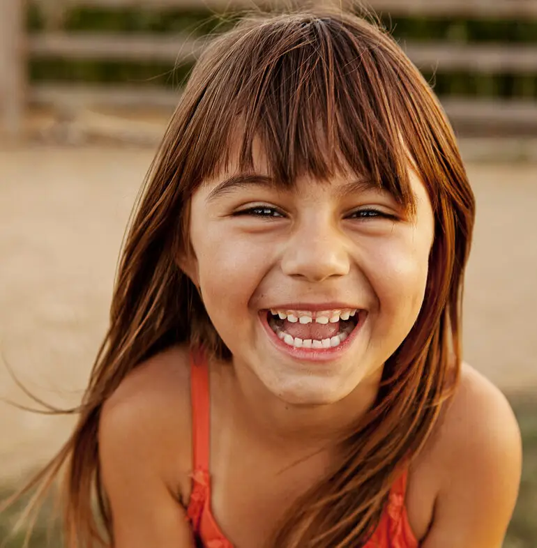 Una niña riendo al aire libre